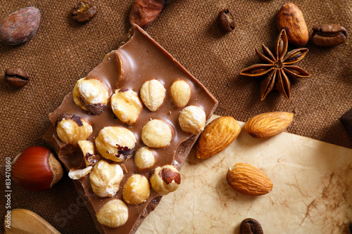Delicious chocolates with nuts spices on table, closeup