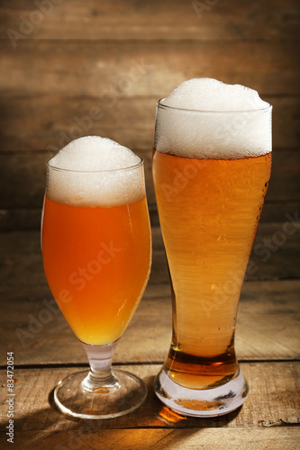 Glasses of beer on wooden background