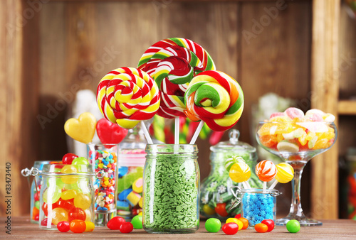 Colorful candies in jars on table in shop