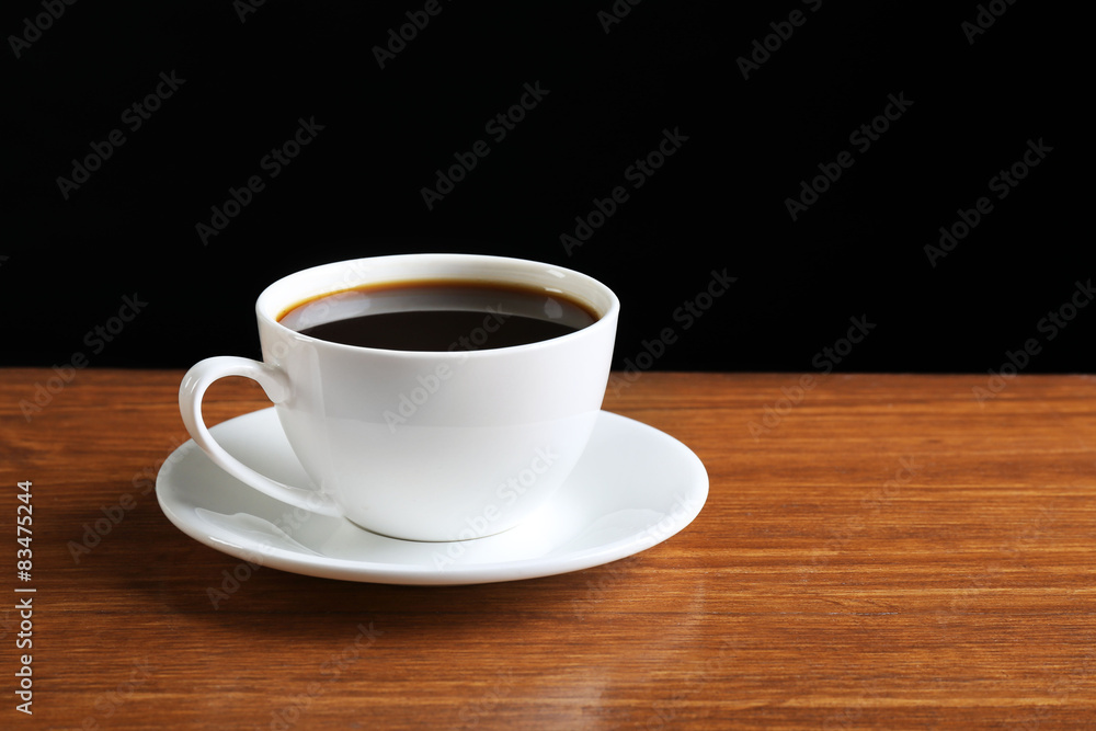 Cup of coffee on table on dark background