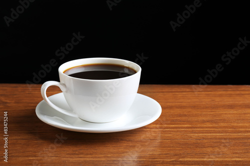 Cup of coffee on table on dark background