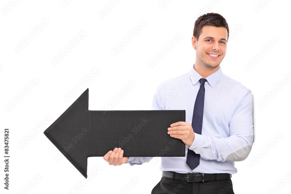 Happy young businessman holding a big black arrow pointing right Happy young businessman holding a big black arrow pointing right