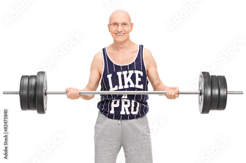 Senior man in a dark blue jersey, exercising with a barbell and