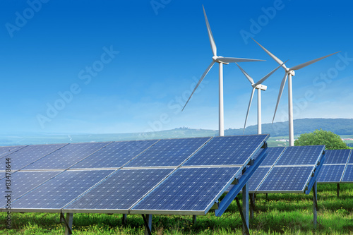 solar panels and wind turbines under blue sky
