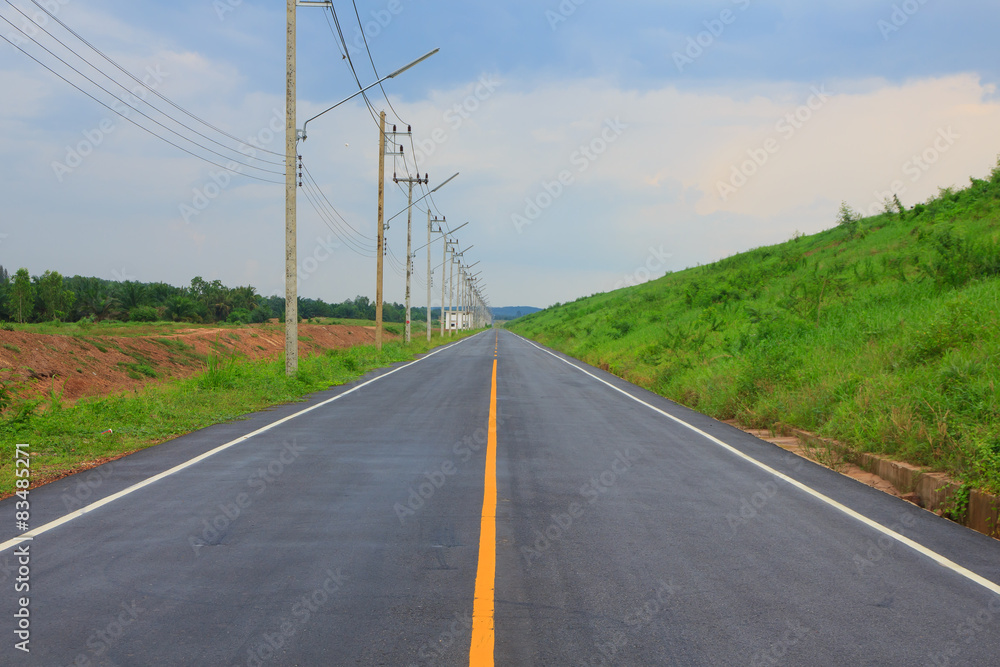 Stock Photo - Empty road and the yellow traffic lines with cloud