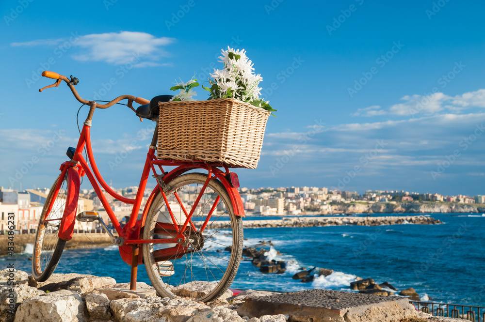 Old red bicycle along the seafront of Syracuse, Sicily