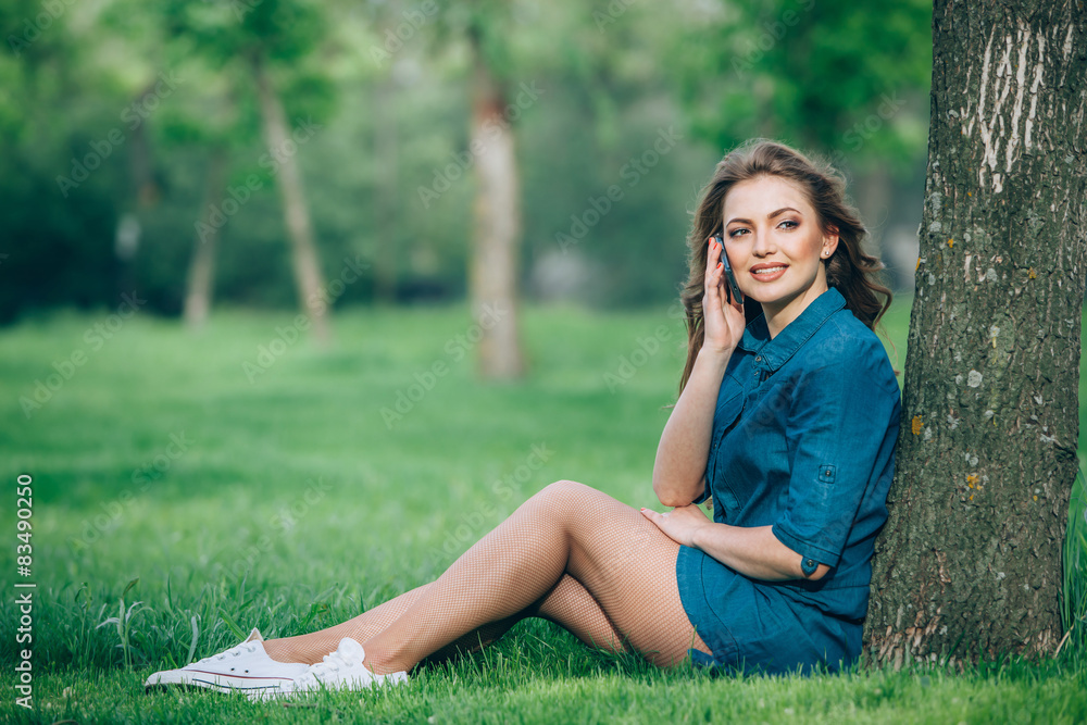 Pretty young caucasian woman sitting outside under a tree Pretty young caucasian woman sitting outside under a tree