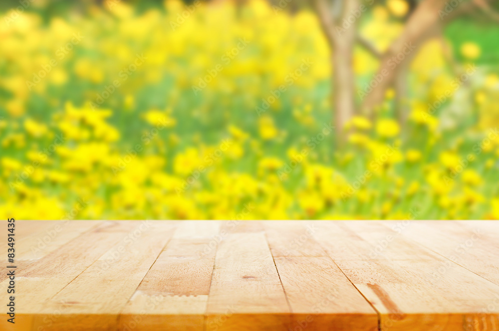 Wood table top on blurred background of beautiful yellow flower