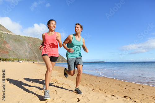 Runners running on beach - jogging couple © Maridav