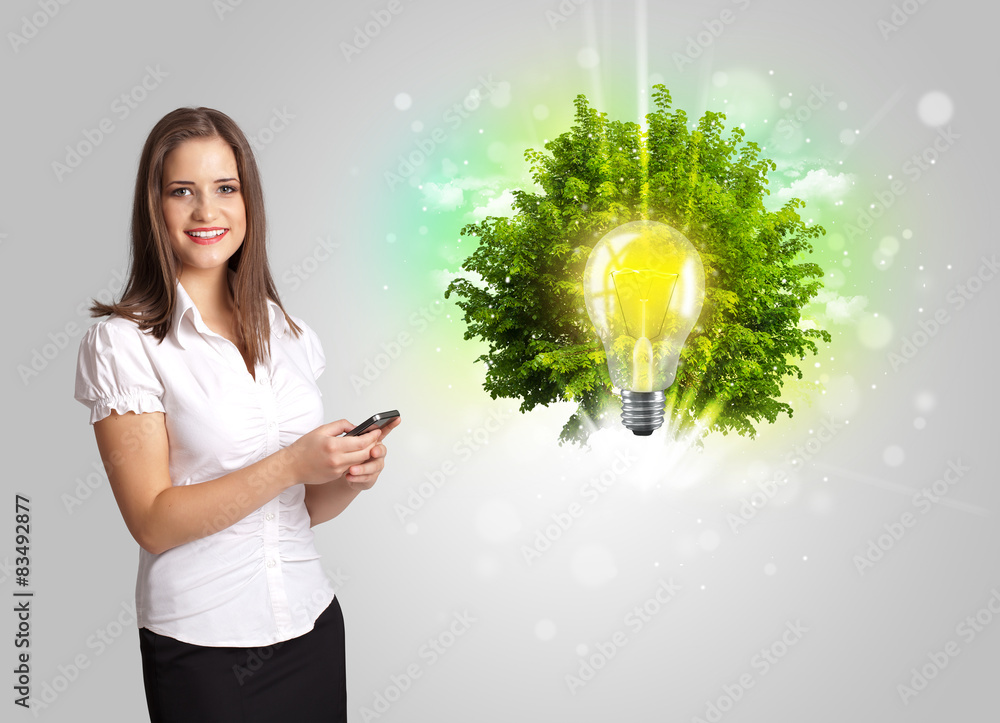 Young girl presenting idea light bulb with green tree Young girl presenting idea light bulb with green tree
