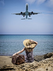 Woman with vintage leather travel bag on the beach