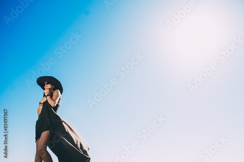 beautiful girl in black long dress on a background of blue sky © jul14ka