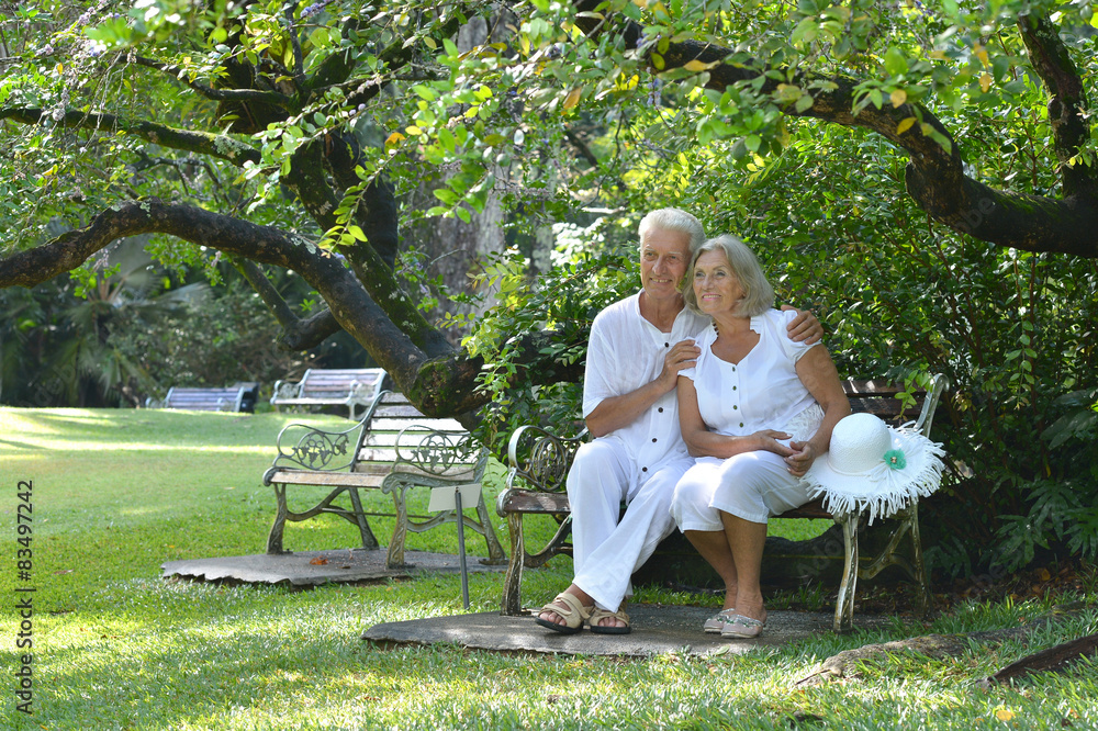 Elderly couple sitting on a bench outdoors Elderly couple sitting on a bench outdoors