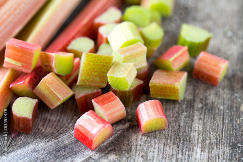 freshly cut pieces of rhubarb on wooden surface