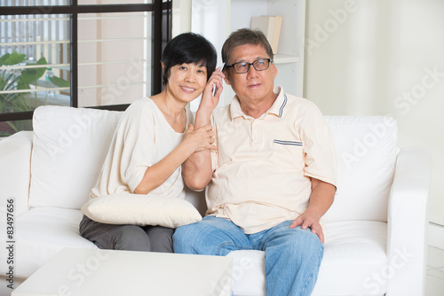 asian senior couple having phone conversation