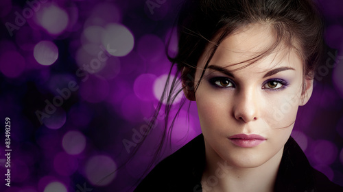 Brunette girl with  make-up on a dark background sparkling