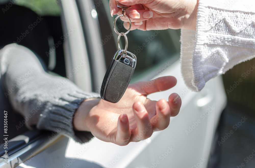 Woman giving car key to a man