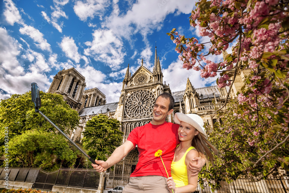 Fototapeta premium Couple Taking Selfie by Notre Dame cathedral in Paris, France