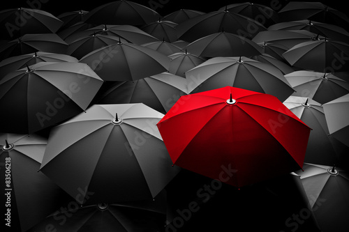 Red umbrella stand out from the crowd. Different  leader.