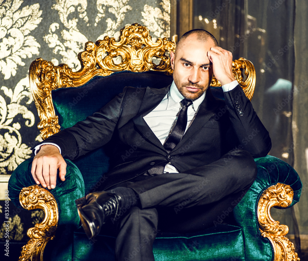 Man in a suit sitting on chair. Stock Photo Adobe Stock