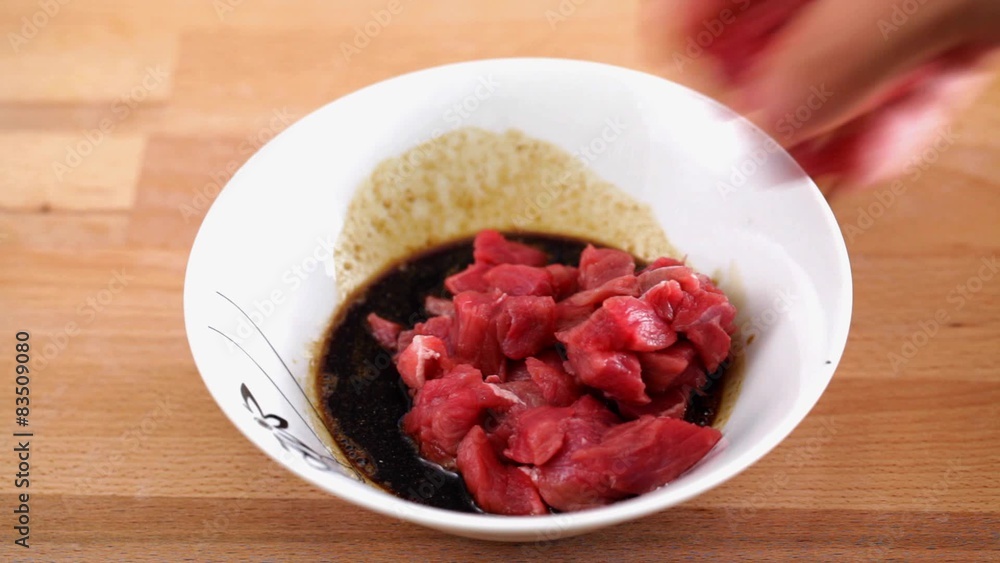 Beef chunks soaking in dark soy sauce marinade
