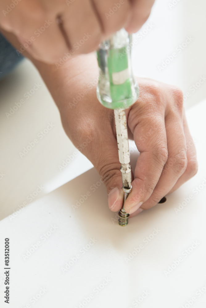 Woman's hand using a screw driver Woman's hand using a screw driver