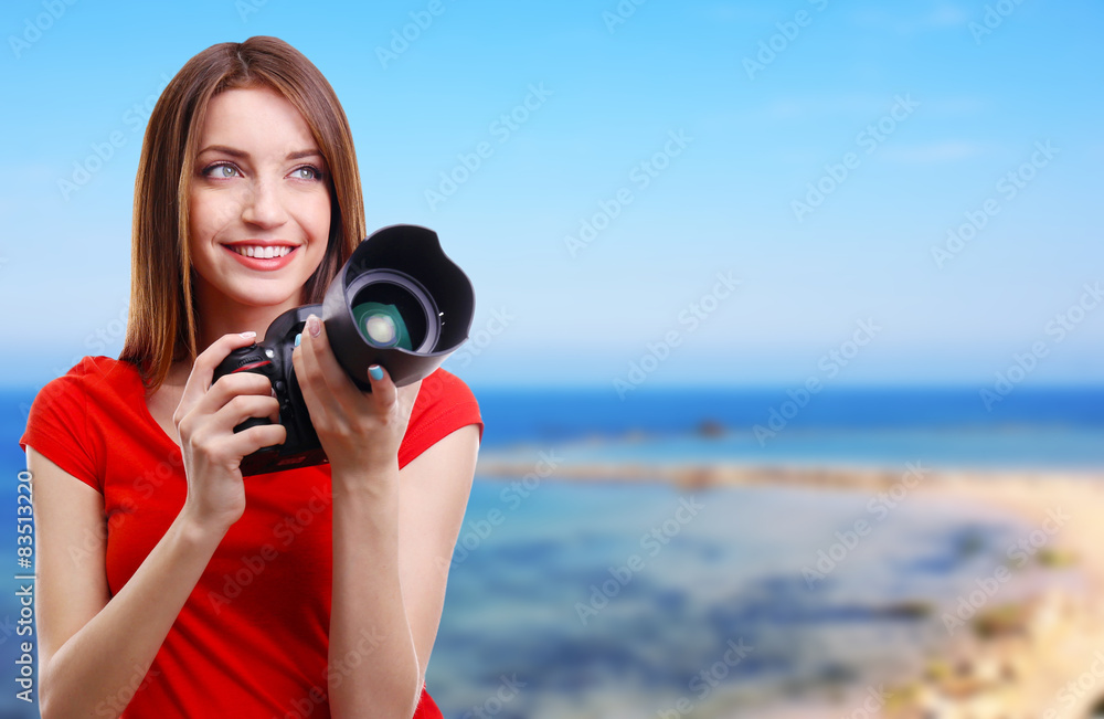 Fototapeta premium Young female photographer taking photos on nature background