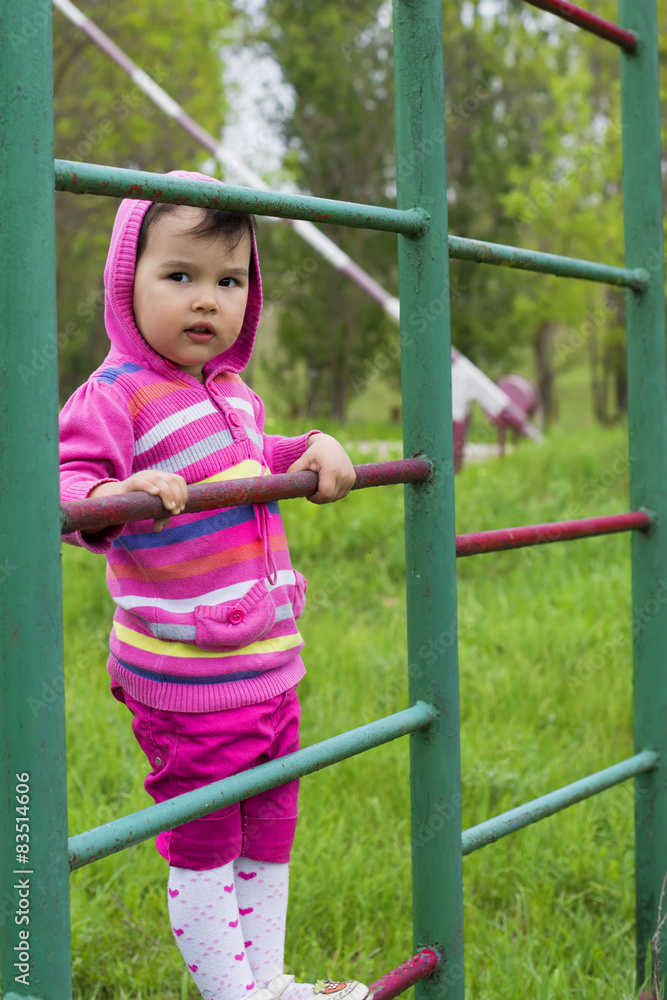 Happy little girl climbing on outdoor playground Happy little girl climbing on outdoor playground