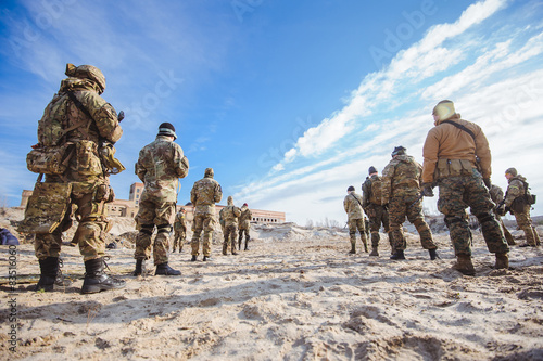 Men in military uniform while training outdoors.