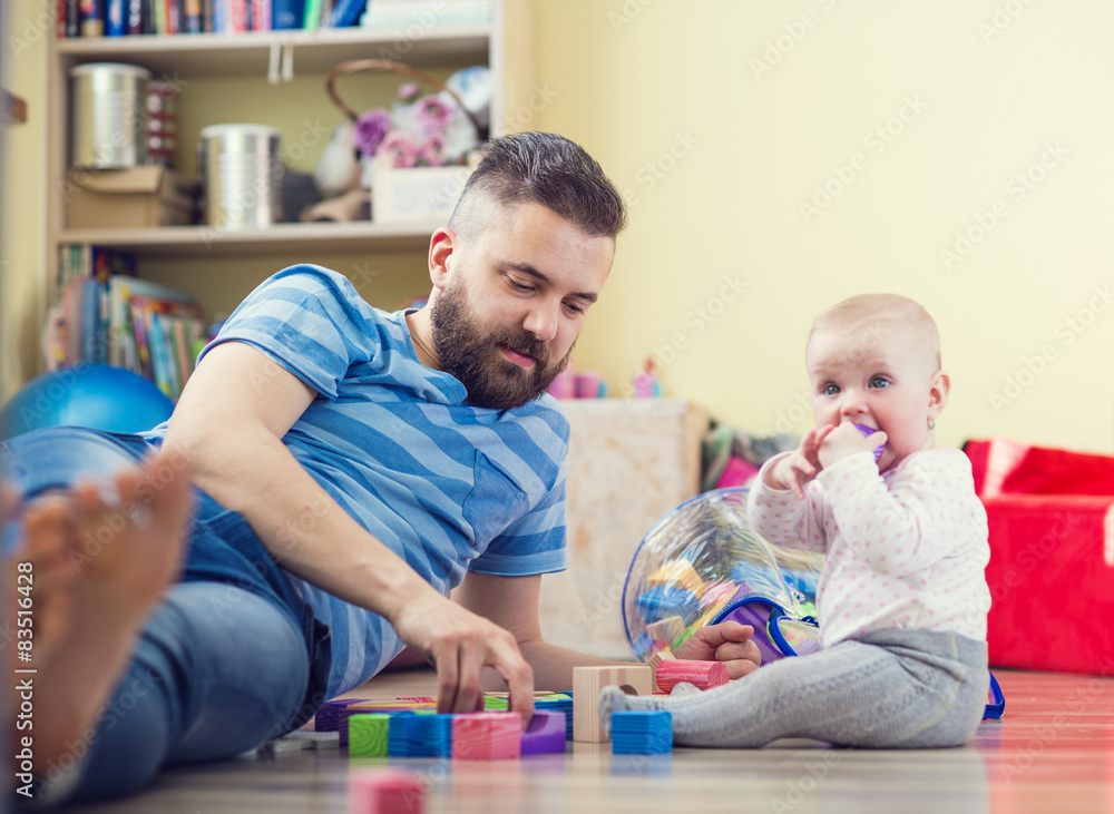 Young father playing on the floor with his little daughter Young father playing on the floor with his little daughter