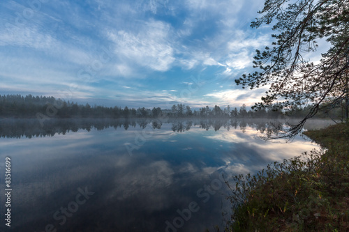 Early morning sky and clouds reflected in a small pond