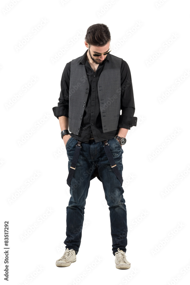 Modern trendy man with hands in pockets looking down Modern trendy man with hands in pockets looking down