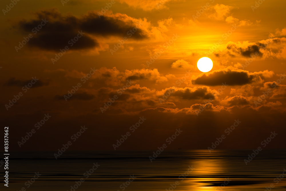 Dramatic sunset behind clouds above the sea Dramatic sunset behind clouds above the sea