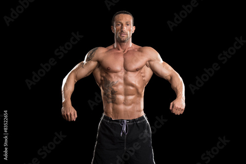 Muscular Bodybuilder Man Posing Over Black Background
