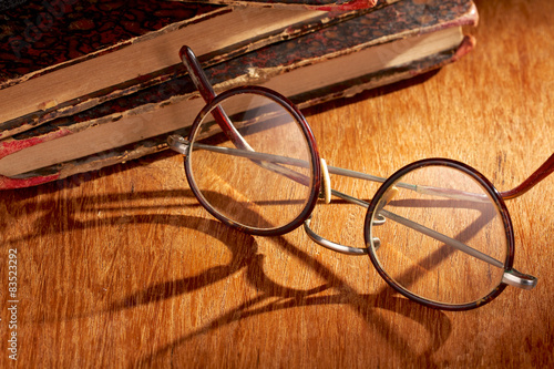 Long shadow from vintage eyewear over a wooden table 