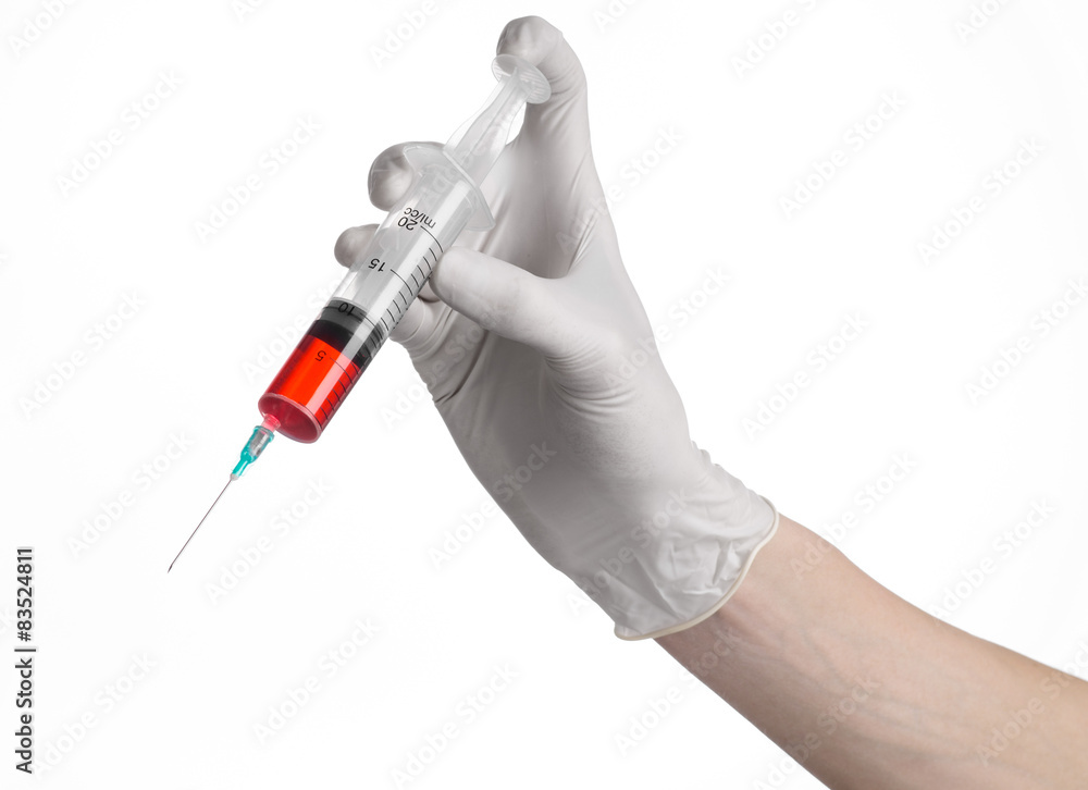 Doctor's hand holding a syringe, large syringe, red medication Doctor's hand holding a syringe, large syringe, red medication