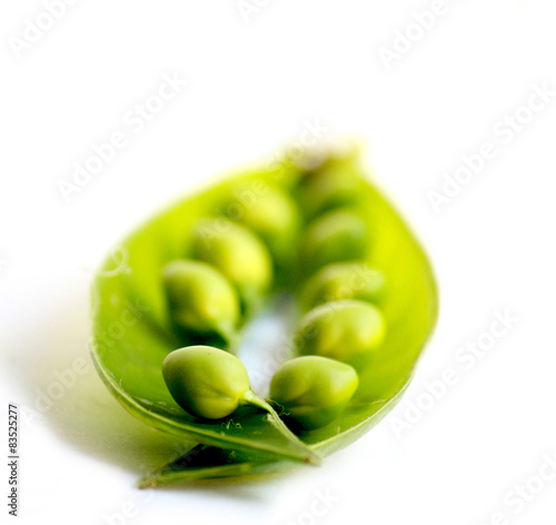 Close-up of an open pea pod and peas on a white background photo