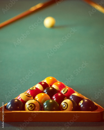 Close-up shot of pool balls in wooden triangle with cue ball in blurred background