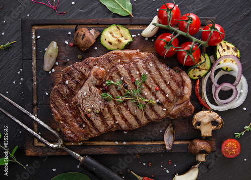 Fotografie Beef steak on wooden table
