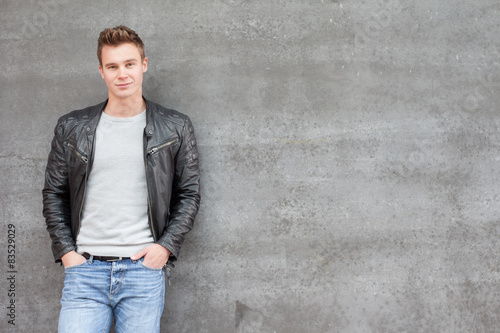 Casual young guy in front of concrete wall