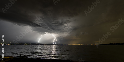 Lighting strike over Estavayer-le-Lac at night, District de la Broye, Fribourg, Switzerland photo