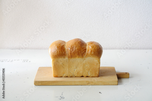 Close-Up of a Loaf of homemade white bread on a wooden chopping board photo