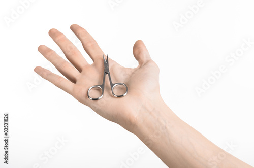 Hand holding scissors for manicure isolated on white background