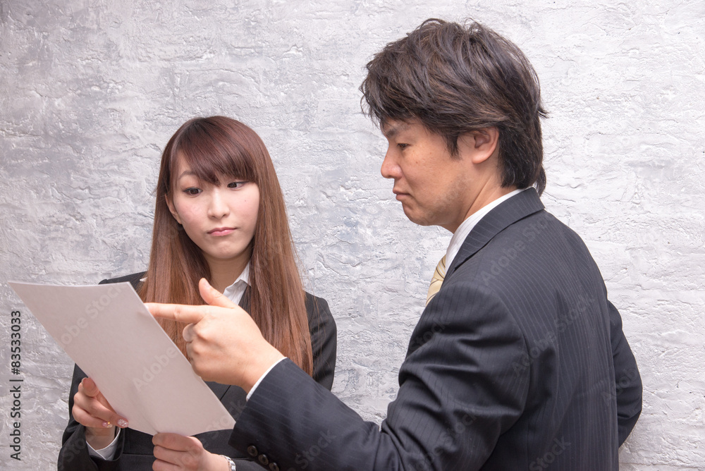 オフィスで指示を出す上司の男性と話を聞く女性 オフィスで指示を出す上司の男性と話を聞く女性