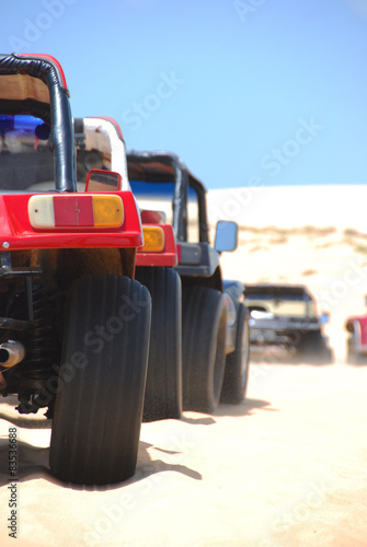 Brazil, Northeast Region, Ceara, Jijoca de Jericoacoara, Beach buggies parked in row on sand photo