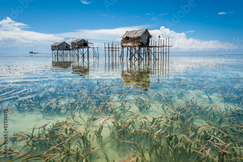 Malaysia, Borneo, Sabah, Tawau, Semporna, Stilt huts reflected in sea shoals overgrown with seaweed