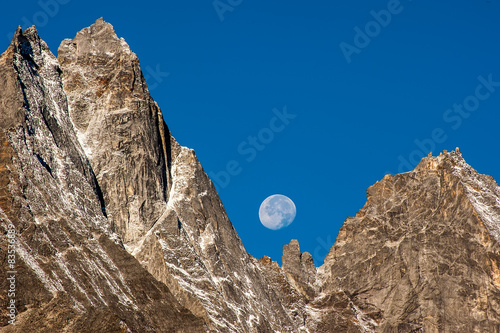 Himalayas, Kumbu, Moon visible behind rocky mountains in blue sky during day photo
