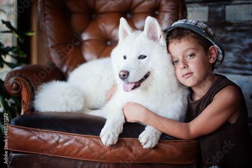 Portrait of boy (8-9) with samoyed dog photo