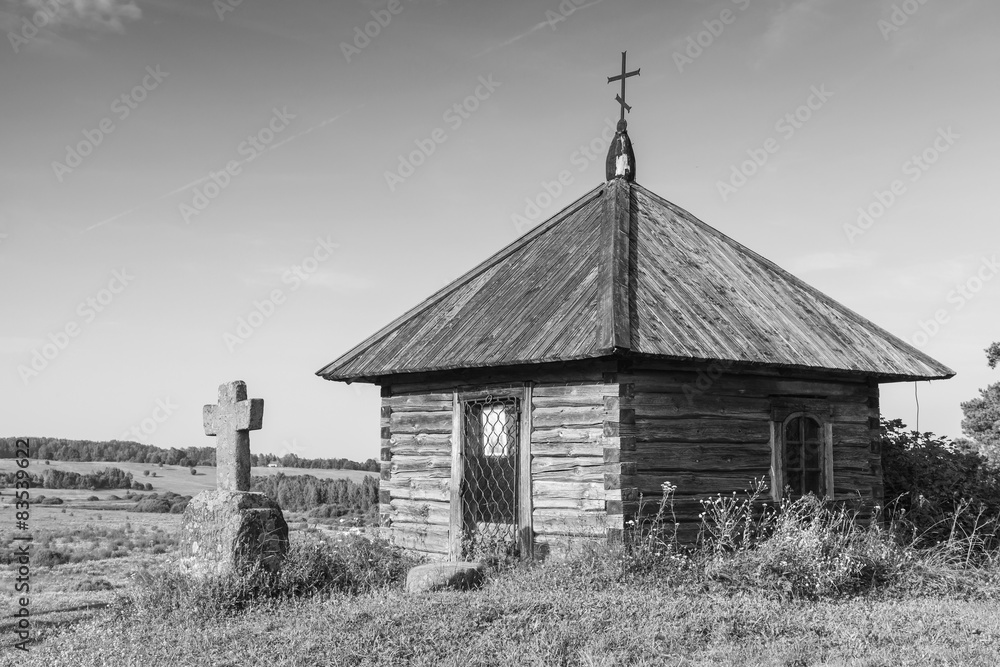 Ancient wooden Orthodox chapel and a stone cross Ancient wooden Orthodox chapel and a stone cross