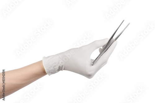 doctor's hand in a white glove holding tweezers isolated studio